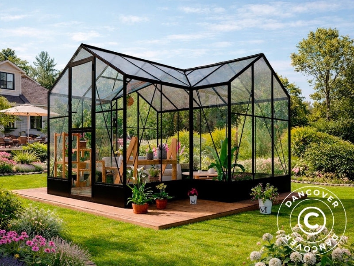 Black glass orangery against a stone wall