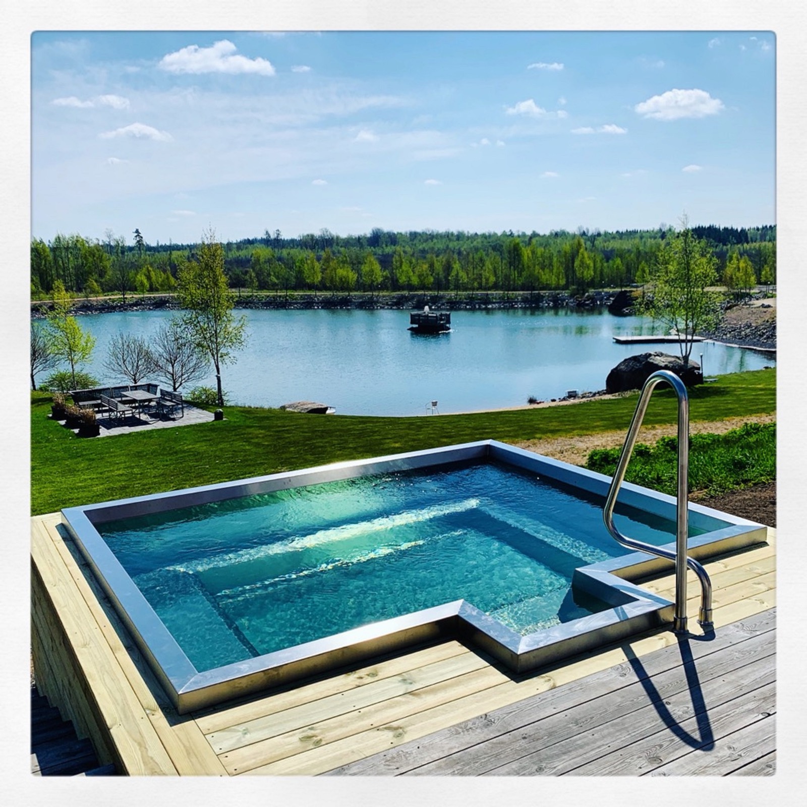 Stainless steel pool on a deck facing a lake