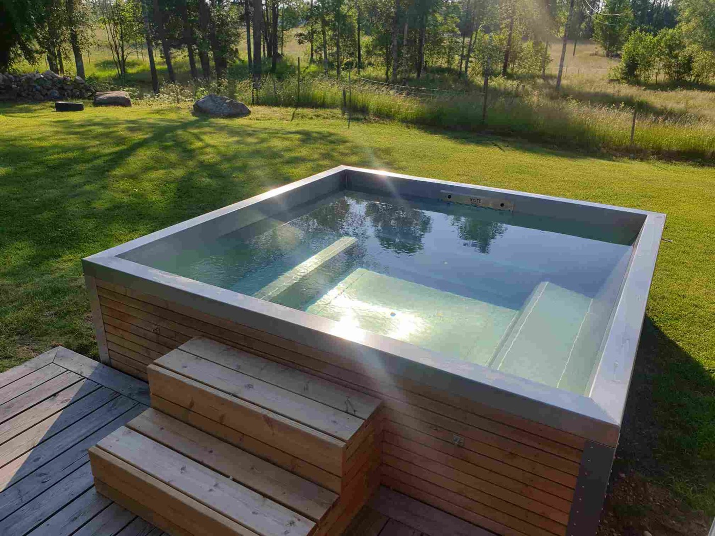 Square stainless steel spa bath set into a wooden deck